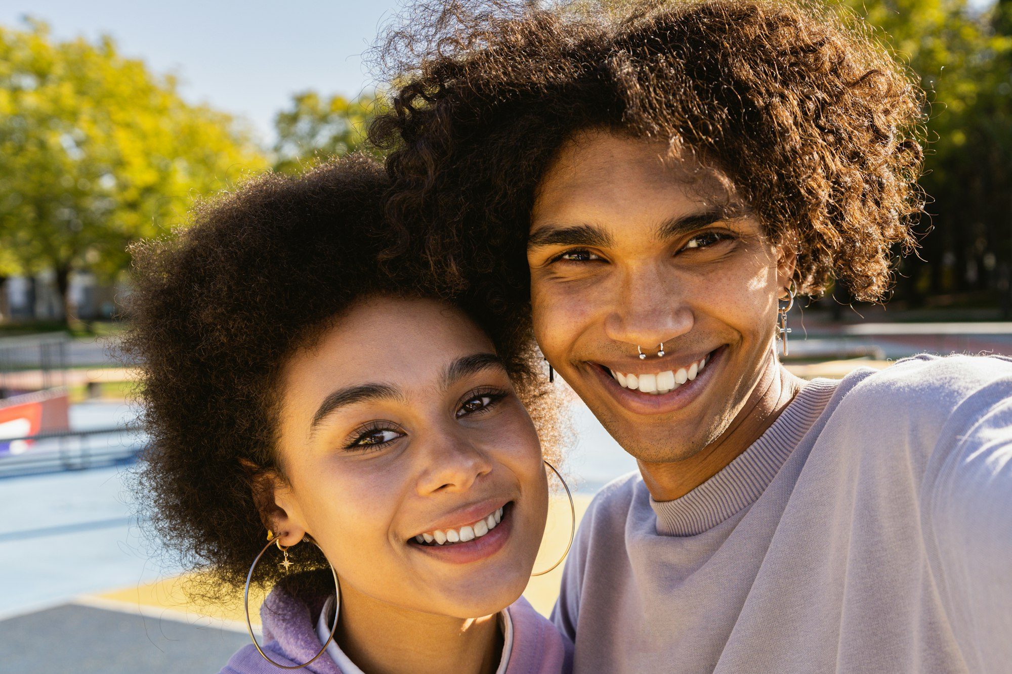 Interracial young couple dating outdoors, colored and modern urban background